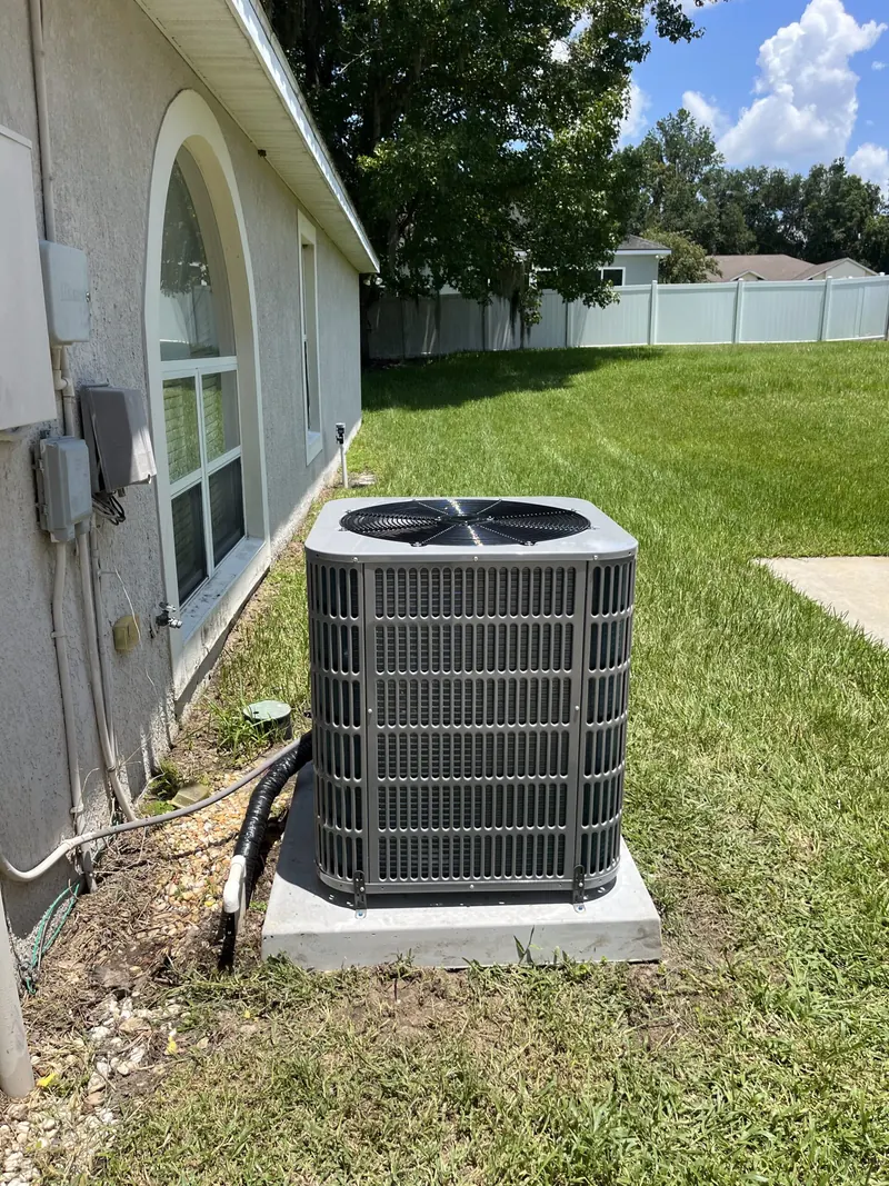 Newly installed outdoor AC condenser on a concrete pad beside a Central Florida home