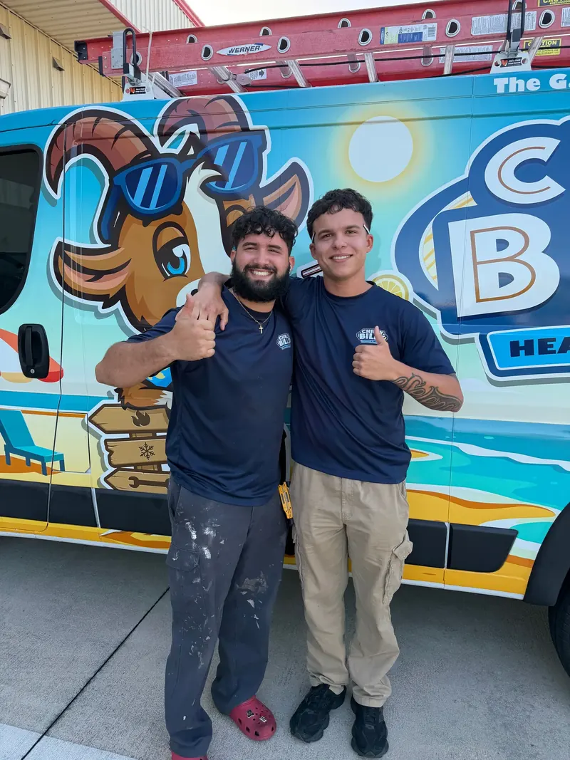 Two men in navy Chilly Billy shirts giving a thumbs-up in front of the company's goat-mascot service van