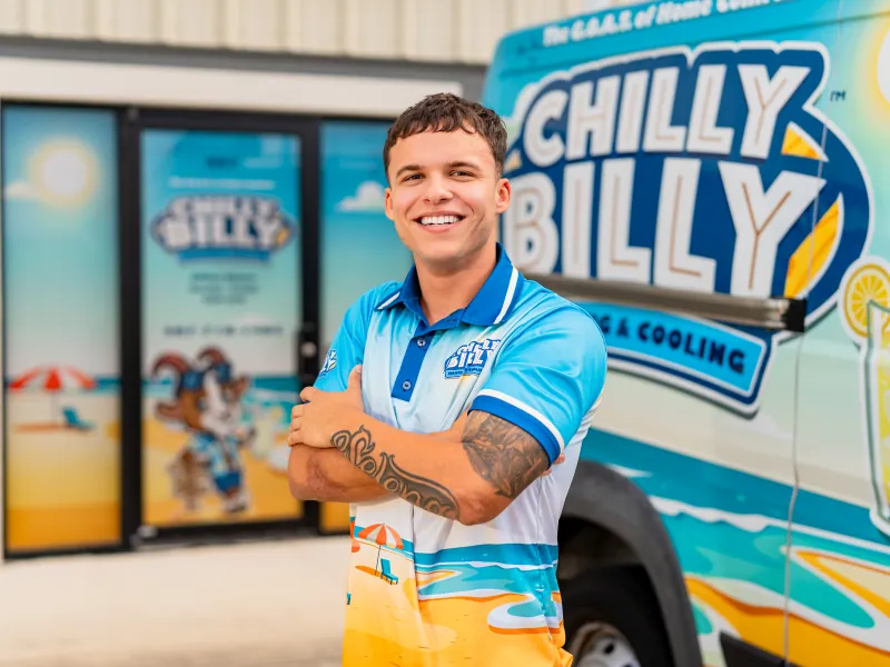 Josh, service technician at Chilly Billy Heating & Cooling, in a company polo in front of the service van