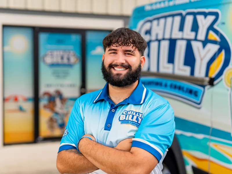 Nas, install and service technician at Chilly Billy Heating & Cooling, in a company polo by the service van